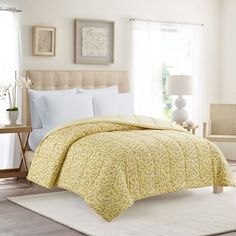 a bed with yellow and white bedspread in a bedroom