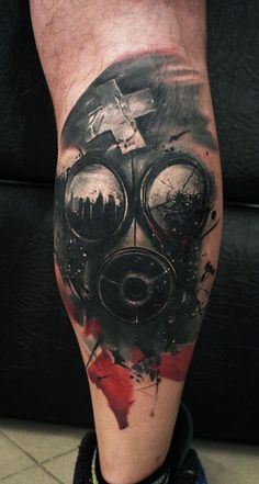 a man's leg with a gas mask tattoo design on it and some paint splatters