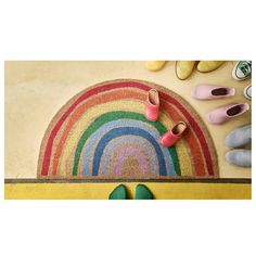 two pairs of shoes are sitting on the floor next to a rainbow rug and slippers