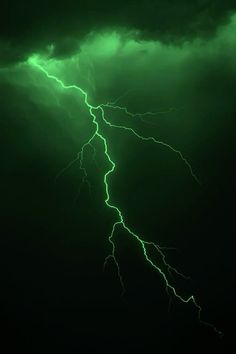 a green and black background with lightning in the sky