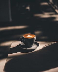 a cappuccino sitting on top of a saucer in the sun light