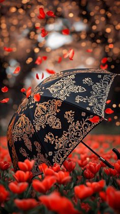 an open umbrella sitting in the middle of red flowers