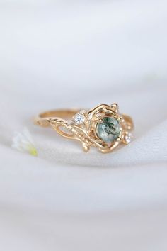 a close up view of a ring with an aqua stone in the center and two diamonds on it