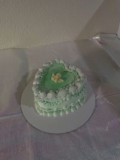 there is a cake on the table that has been decorated with green icing and white frosting