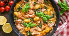 a skillet filled with chicken, potatoes and spinach on top of a table