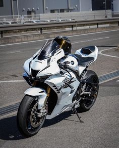 a white motorcycle is parked on the side of the road in front of some buildings