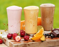 three different types of smoothies on a table with strawberries, lemons and raspberries