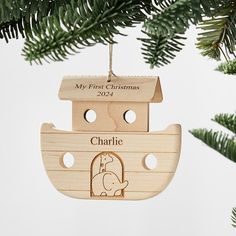 a wooden ornament hanging from a christmas tree with an elephant in a boat