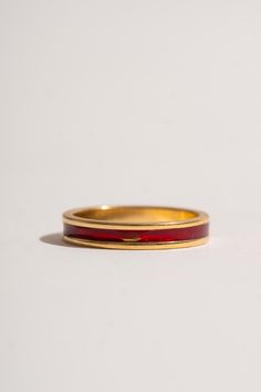 18K gold band adorned with a ring of red enamel. Beautiful alone or incorporated into a stack to add a pop of color. Please note, this band has a spot on the edge of the enamel that has rubbed off. We believe these signs of wear are evidence of a vintage item’s colorful past and add to their individual charm. 18K Yellow Gold + Red Enamel Please note, this item is final sale. Red Enamel Elegant Rings, Elegant Red Enamel Ring, Classic Red Enamel Jewelry, Formal Red Stackable Rings, Pantry Decor, Garden Clogs, Black Crane, On The Edge, Gold Band