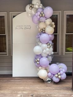 the balloon arch is decorated with white, lavender and silver balloons