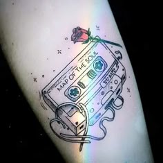 a tattoo on the leg of a person with a cassette tape and a rose attached to it