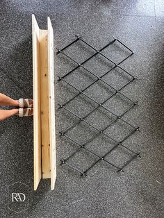 a person standing next to a wooden box on top of a black carpeted floor