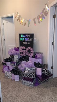 the birthday presents are piled on top of each other in purple and black boxes with ribbons