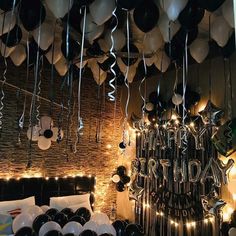 balloons and streamers hang from the ceiling above a bed in a room decorated for a party