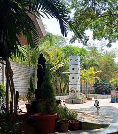 there is a statue in the middle of a courtyard with many potted plants around it