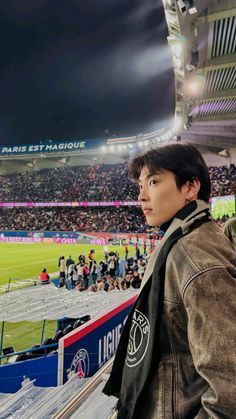 a man standing in front of a stadium filled with people