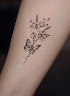 a small butterfly and flower tattoo on the arm