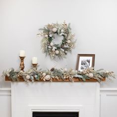 a mantel decorated with greenery and candles