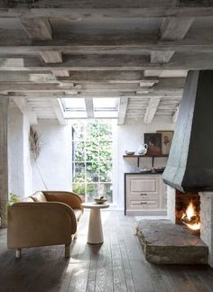 a living room filled with furniture and a fire place in the middle of it's walls