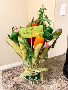 a vase filled with lots of vegetables on top of a counter next to a sign that says i love you a great dill