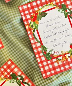 a red and white checkered table cloth with some cards on it