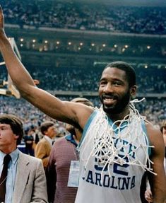 a basketball player is holding his trophy in the air