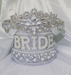 "This listing is for a \"Silver or Iridescent\" themed bride hat, the main applique will be the standard design, it will come in silver unless stated Each hat has its own unique style so it may vary from photos, if you like any features shown in the pictures please get in contact prior to discuss your hat. The hat can be personalised with the word bride for that special hen, a word/name or for a special milestone birthday.  **Please note that if anything other than \"BRIDE\" or an age is considered a custom hat, letters are charged at £2.50, Please select the amount of letters that the word contains from the \"Custom Letters\" drop down E.G. Names/Baby boy/bridesmaid ETC. If you require a \"BRIDE or AGE\" hat please select \"BRIDE/AGE\" from the \"Custom Letters\" drop down Please be aware Adjustable Silver Party Hat, Adjustable Crown Costume Hat For Wedding, Silver Tall Crown Headpiece For Party, Adjustable Crown Wedding Costume Headpiece, Adjustable Crown Wedding Headpiece, Silver High Crown Hat For Party, High Crown Silver Hat For Party, Silver Party Headpiece, Silver Structured Crown For Party