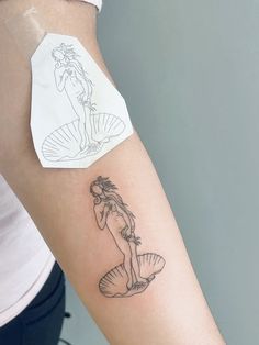 a woman with a mermaid tattoo on her arm