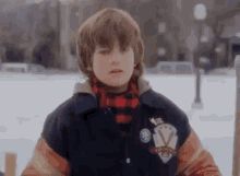 a young boy is standing in the snow