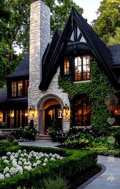 a house that is surrounded by plants and flowers