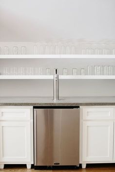 a stainless steel dishwasher sitting in the middle of a kitchen