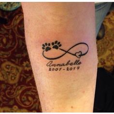 a dog paw tattoo on the arm with an animal's name and heart in it