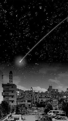 a black and white photo of the sky with cars parked in front of buildings under a shooting star