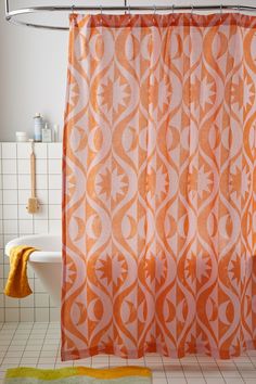 an orange and white shower curtain in a bathroom