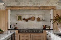 a kitchen with wooden cabinets and marble counter tops, hanging utensils on the wall