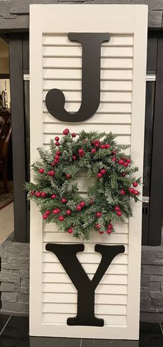 a sign that has a wreath on it and the letter j is made out of wood