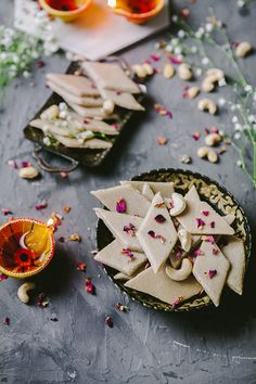 some food is sitting on a table with glasses and confetti in the background