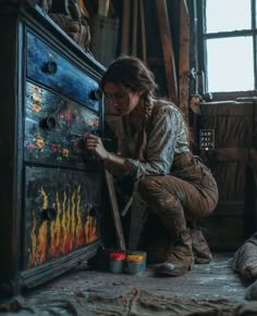 a woman is painting on an old dresser