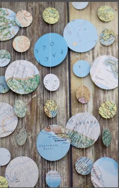 a wooden table topped with lots of different types of paper circles hanging from it's sides