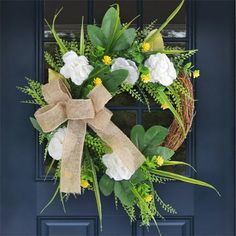 a wreath with white and yellow flowers on a blue door