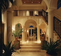 an entry way with stairs and potted plants on either side of the entranceway