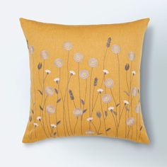 a yellow pillow with white flowers on it