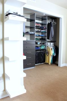 an empty closet with clothes hanging on the shelves and shoes sitting on top of it