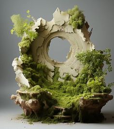 a sculpture made out of moss and rocks with trees in the center, surrounded by other plants