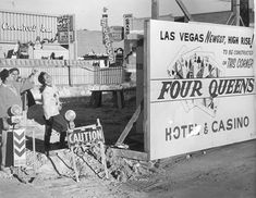 two men standing in front of a sign for four queens hotel and casino, las vegas