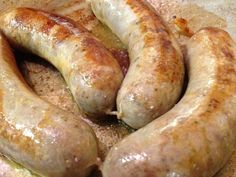 three sausages are sitting in a bowl on the stove top, ready to be cooked