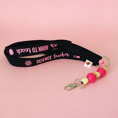 "Be the sparkle of the staff room in this sparkly pink glitter \"Born to Teach\" lanyard! Customize it with your name for a personalized touch. This science teacher gift is perfect for accessorizing and making a statement - learning has never looked so glamorous! Item: Black Science Teacher Lanyard with Pink Glitter Vinyl Print Print: Science Teacher-Born to Teach Makes a great Science Teacher gift! :) Product Features o wide, black lanyard o pink beads o pink glitter vinyl print o one-point saf Personalized Pink Badge Holders For Gifts, Customizable Adjustable Pink Badge Holders, Personalized Black Lanyard For Gift, Personalized Black Lanyards For Gifts, Personalized Black Lanyards As Gift, Adjustable Personalized Pink Lanyard, Personalized Pink Lanyards For Personal Use, Educational Assistant, Teachers Necklace