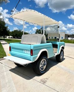 a light blue golf cart parked on the street