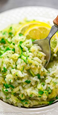 a white plate topped with rice and lemon wedges