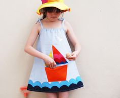 We think you will love the striking simplicity of this applique sun dress. Our out to sea  sun dress makes the perfect pocket pinafore for summer beach holidays. Featuring a rainbow sail boat , silver birds ,and a wave design running around the hemline. The simple design means a perfect easy fit with tie straps and soft chest elastic. Layer with a short sleeve vest top. Made from sky blue cool Linen cotton mix with cotton applique  30 degree wash.Gentle cycle. Iron on reverse. Handmade in the UK Nautical Cotton Summer Dress, Nautical Dresses For Summer Vacation, Nautical Style Summer Vacation Dresses, Nautical Sleeveless Dresses For The Beach, Nautical Sleeveless Beach Dress, Playful Cotton Sundress For Beach, Playful Cotton Sundress For The Beach, Playful Blue Sundress For The Beach, Playful Blue Sundress For Beach